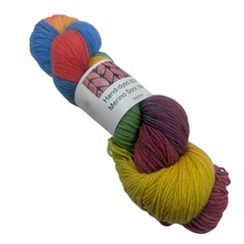Load image into Gallery viewer, Multicolored skein of merino sock yarn with a label on a white background
