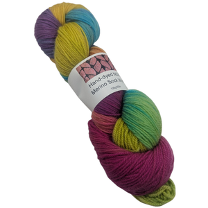 Multicolored skein of merino sock yarn with a label on a white background