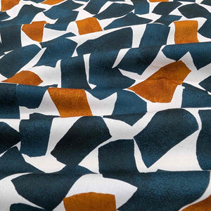 Flat lay of fine cotton, in a falling blocks design, in teal colourway. Made in Japan by Kokka. Available at Minerva's Bower. Fabric draped to show how it handles