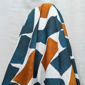 Flat lay of fine cotton, in a falling blocks design, in teal colourway. Made in Japan by Kokka. Available at Minerva's Bower. Fabric draped to show how it handles