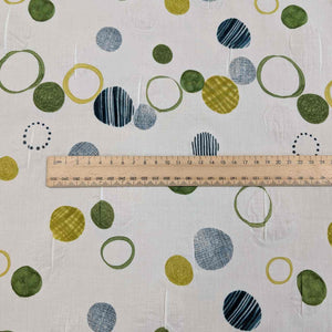 Flat lay of pure cotton seersucker, in green floating circles design. Made in Japan by Kokka. Available at Minerva's Bower. Ruler included for scale