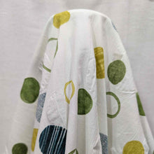 Load image into Gallery viewer, Flat lay of pure cotton seersucker, in green floating circles design. Made in Japan by Kokka. Available at Minerva&#39;s Bower.Fabric draped to show how it handles