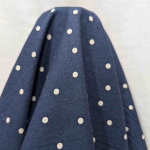 Flat lay of cotton linen spot fabric, in navy colourway. Made in Japan, by Kokka. Available at Minerva's Bower. Fabric draped to show how it handles