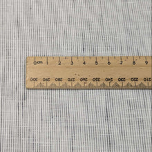 Load image into Gallery viewer, Flat lay of pure linen in a fine charcoal pinstripe. Available at Minerva&#39;s Bower. Ruler included for scale of stripe