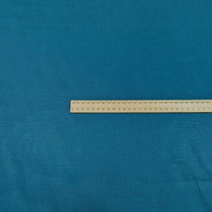 Flat lay of pure flax linen in petrol. Available at Minerva's Bower. Ruler included for scale