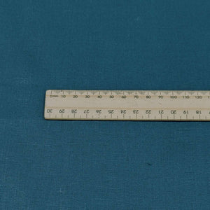 Flat lay of pure flax linen in petrol. Available at Minerva's Bower. Ruler included for scale
