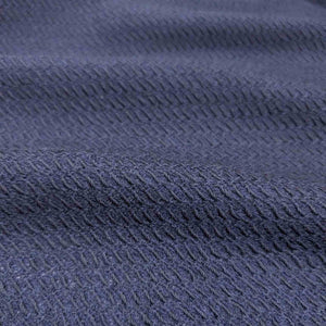 Flat lay of Japanese pure textured wool Moss, in indigo colourway. Available at Minerva's Bower. Fabric draped to show how it handles
