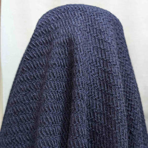 Flat lay of Japanese pure textured wool Moss, in indigo colourway. Available at Minerva's Bower. Fabric draped to show how it handles