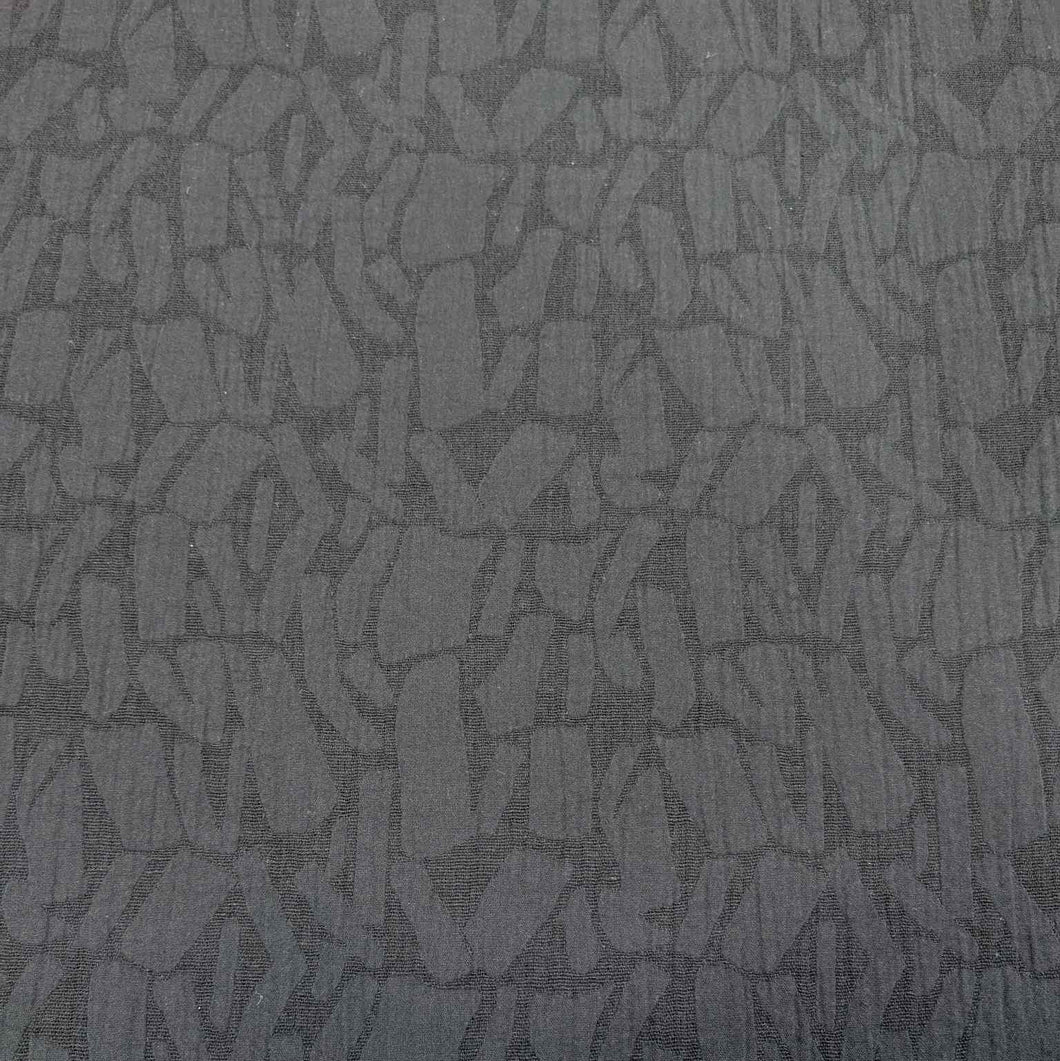 Textured black muno jacquard patterned fabric. Available at Minerva's Bower