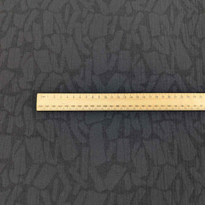 Black Muno jacquard textured fabric with a ruler for scale. available at Minerva's Bower