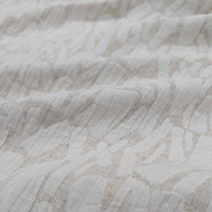 Close-up of textured cream muno jacquard fabric with a subtle pattern. Available at Minerva's Bower