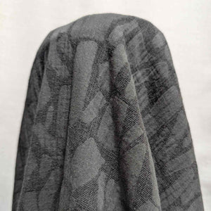 Graphite muno jacquard textured fabric draped over a white background. Available at Minerva's Bower