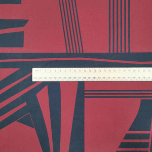 Metropolis is a dramatic, large scale graphic print. Pure cotton, with black on a claret red background, available at Minerva's Bower. Image includes a ruler for scale