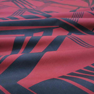 Metropolis is a dramatic, large scale graphic print. Pure cotton, with black on a claret red background, available at Minerva's Bower. Fabric is draped across bench