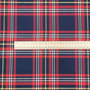 Chloe is a pure cotton tartan twill. A navy blue base, with lines of red, white and yellow, to create the plaid effect. Available at Minerva's Bower. Image includes a ruler for scale