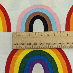 Alexander Henry cotton Fabric with rainbow pattern and a wooden ruler for scale, for sale at Minerva's Bower