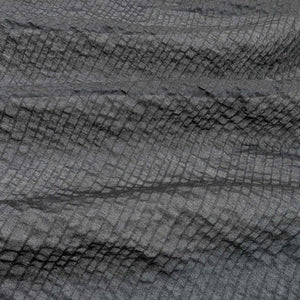 Flat lay of pure cotton voile seersucker self stripe, in black colourway. Available at Minerva's Bower. Fabric draped to show how it handles