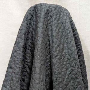 Flat lay of pure cotton voile seersucker self stripe, in black colourway. Available at Minerva's Bower. Fabric draped to show how it handles