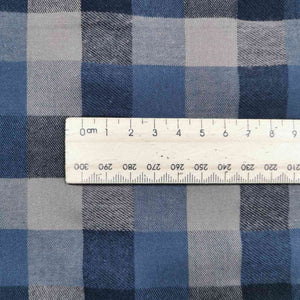 Shetland Check is a beautful yarn dyed linen cotton fabric. It is woven in tones of blues and taupe, and is available at Minerva's Bower. Image includes a ruler for scale