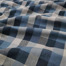 Load image into Gallery viewer, Shetland Check is a beautful yarn dyed linen cotton fabric. It is woven in tones of blues and taupe, and is available at Minerva&#39;s Bower. Fabric is draped across bench