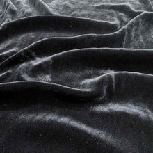 Load image into Gallery viewer, Flat lay of pure silk velvet in black colourway. Available at Minerva&#39;s Bower. Fabric draped to show how it handles