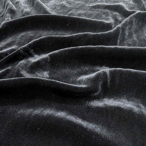 Flat lay of pure silk velvet in black colourway. Available at Minerva's Bower. Fabric draped to show how it handles