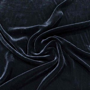 Flat lay of pure silk velvet in black colourway. Available at Minerva's Bower. Fabric draped to show how it handles