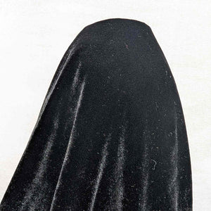 Flat lay of pure silk velvet in black colourway. Available at Minerva's Bower. Fabric draped to show how it handles